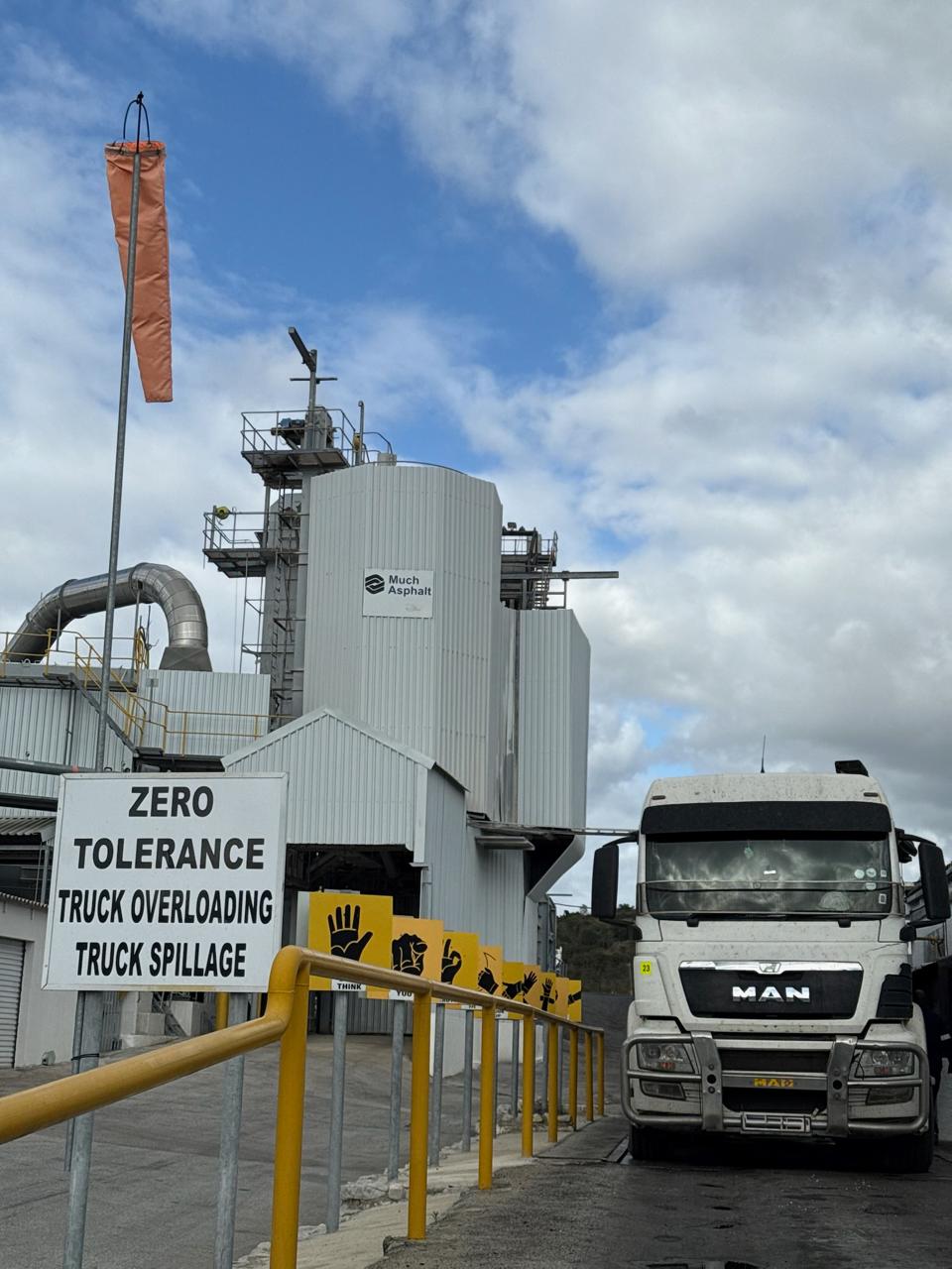 CWG MAN truck at Much Asphalt plant with industrial wind sock and plant